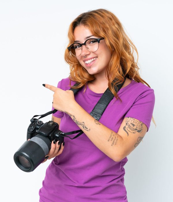 Young photographer caucasian woman isolated on white background pointing back
